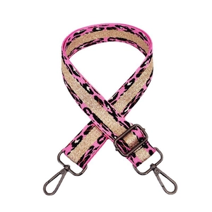 Close-up of thick leopard print bag strap with pink and gold weave and metal buckles