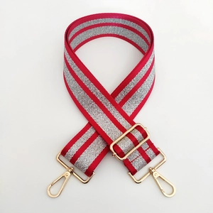 Detail of red and silver glitter strap with gold metal hooks and adjustable buckle