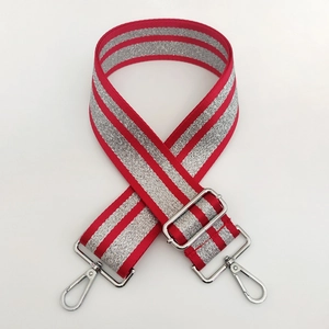Detail of adjustable red and silver stripe woven bag strap with shiny metal lobster clasps