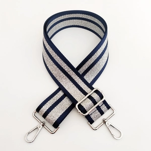Macro shot of adjustable navy and silver striped bag strap with metallic swivel hooks