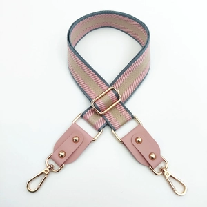 Detail of adjustable woven strap with pink and blue stripes and gold lobster clasp