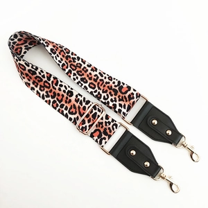 Detail of adjustable leopard print bag strap with black leather and gold hardware