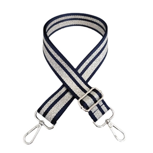 Macro detail of navy and silver woven bag strap with metallic swivel hooks and buckle