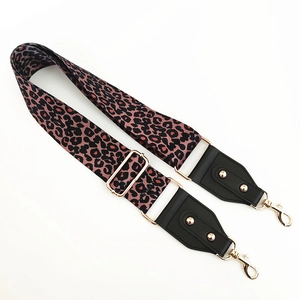Detail of adjustable leopard print bag strap with golden metal swivel hooks and buckles