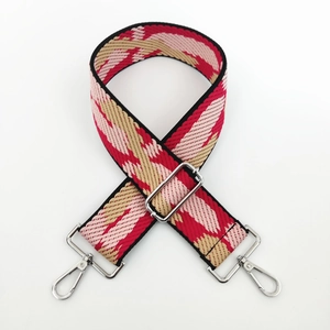 Detail of adjustable woven wide bag strap with ethnic red and pink wave pattern
