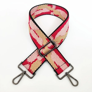 Detail of adjustable woven wide strap with red and beige geometric wave patterns