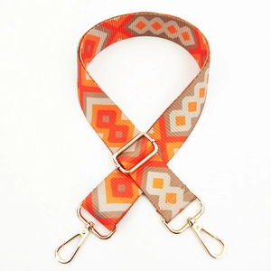 Close-up of colorful geometric woven bag strap with golden metal lobster clasps