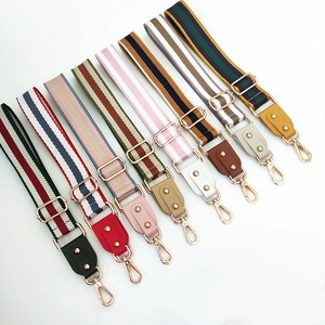 Detail view of multi-color striped shoulder straps with gold metal swivel hooks and buckles