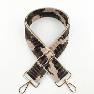 Close-up of adjustable camouflage knit bag strap with gold metal lobster clasps