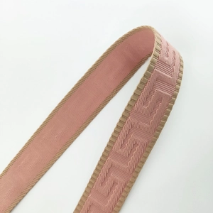 Macro detail of thick pink and beige jacquard shoulder strap with Greek Key pattern