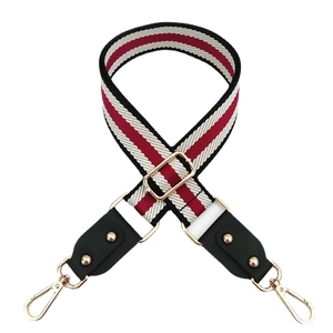 Adjustable woven colorful wide bag strap with red, white, black stripes and gold hardware