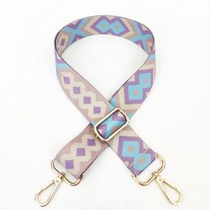 Close-up of geometric woven strap with colorful diamond pattern and gold metal buckles