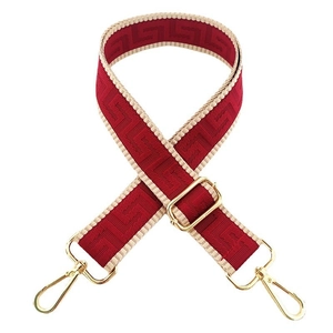 Close-up of red Greek Key patterned wide bag strap with gold metal lobster clasps