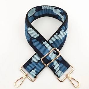Detail of wide adjustable shoulder strap with blue wave pattern and gold metal hooks