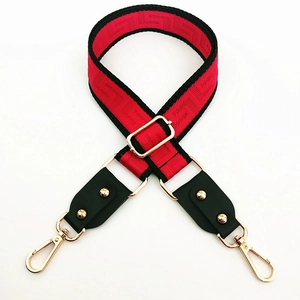 Adjustable red and black patterned wide shoulder strap with gold metal swivel hooks