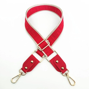 Close-up of adjustable red wide shoulder strap with Greek key pattern and gold hooks