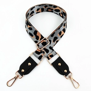Detailed view of adjustable leopard print bag strap with golden hardware and leather ends