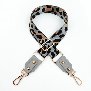 Close-up of leopard print bag strap with adjustable gold buckle and grey leather details