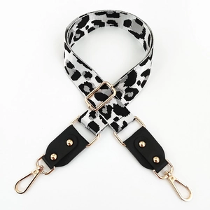 Close-up of leopard print crossbody bag strap with golden lobster clasps and adjusters