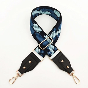 Detail of adjustable wide shoulder strap with blue cloud pattern and golden buckles