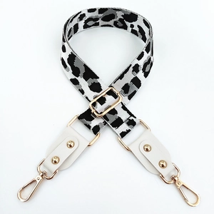 Macro shot of adjustable wide guitar style bag strap with leopard print and gold hardware
