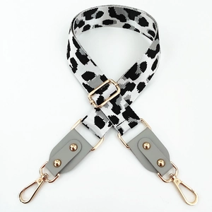 Macro detail of leopard print bag strap with golden hardware and adjustable buckle
