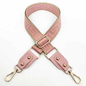 Adjustable woven pink and beige crossbody strap with gold hardware and jacquard pattern