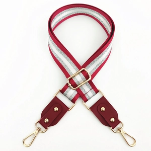 Detail of red and white striped wide bag strap with silver glitter and gold rivets