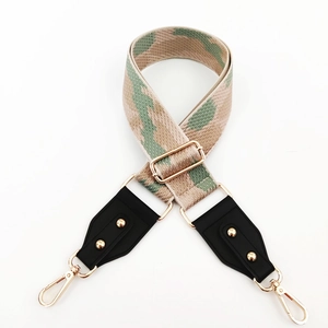 Macro view of adjustable camo shoulder strap with gold metal buckles and lobster clasps