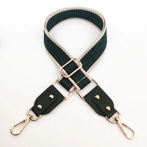 Detailed view of adjustable green woven wide shoulder strap with gold metal lobster clasps