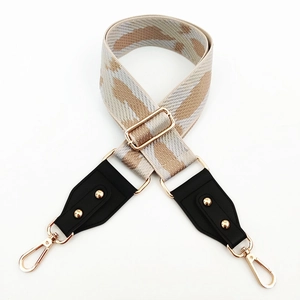 Detail of adjustable wide shoulder strap with camouflage pattern and gold hardware