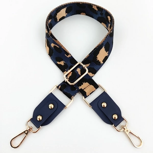 Close-up of leopard print crossbody bag strap with gold metal hooks and blue leather