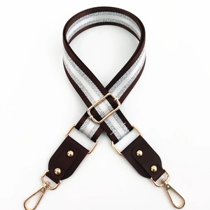 Detail of adjustable brown bag strap with glittery silver stripes and gold hardware