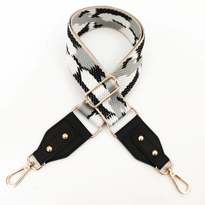 Macro view of wide geometric camouflage strap with premium gold hardware and lobster clasps