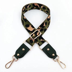 Detail of colorful leopard print nylon strap with gold hardware and green leather ends
