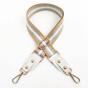 Detail view of khaki canvas strap with silver stripes, leather joints, and gold metal rivets
