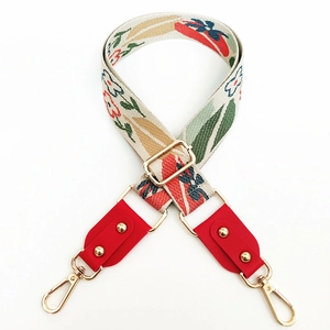 Close-up of floral jacquard embroidery bag strap with gold metal lobster clasps