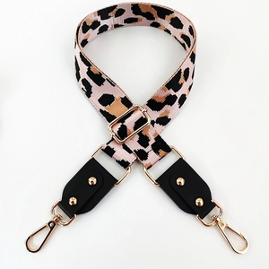 Detail of adjustable leopard print bag strap with gold metal hooks and pink webbing