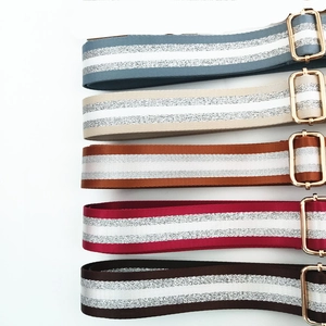 Detail of adjustable woven straps with silver glitter stripes and gold buckles