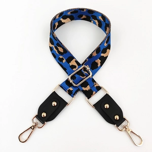 Detail of adjustable leopard print bag strap with gold metal buckles and black leather ends