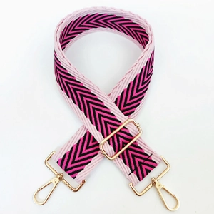 Close-up of pink and black chevron pattern wide guitar strap with gold metal buckles