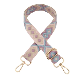 Close-up of geometric pattern jacquard bag strap with golden metal lobster clasps