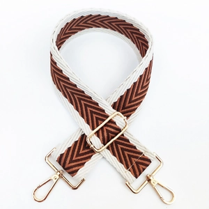 Detail of adjustable woven chevron strap with gold-tone metal hardware and lobster clasps