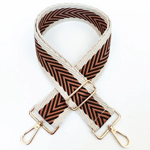 Detail of adjustable 5cm woven bag strap with chevron pattern and gold metal hooks