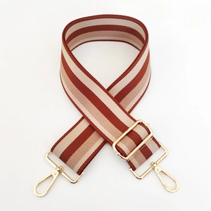 Detail of adjustable 5cm wide striped bag strap with premium polished gold metal clasps