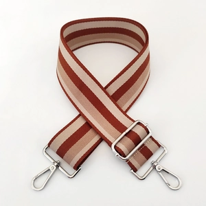 Close-up of wide red and white striped canvas strap with adjustable silver metal hardware