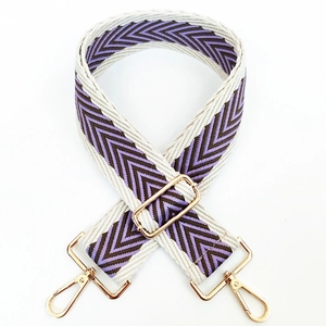 Detail of adjustable woven wide strap with purple V-pattern and gold metal hooks