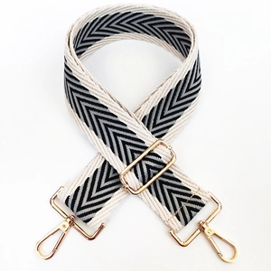Detail of herringbone pattern wide canvas strap with gold metal lobster clasps