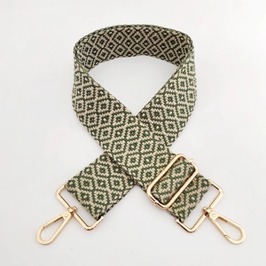 Close-up of geometric jacquard wide bag strap with premium gold metal swivel hooks