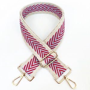 Detail of adjustable woven handbag strap with red and blue chevron pattern and gold clips